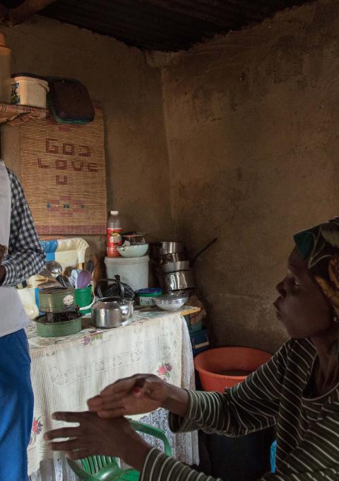 Celumusa Hlatswako, an MSF mobile counselor, visits Winile, 39, XDR-TB patient & HIV-positive. They use sign language to communicate because Winile went deaf due to the side effects of the treatment. Matsapha airport, Manzini Region, Swaziland.